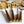 Mádira Wood Bar Tools Set including a gold drink measure, stirrer, ice pick, and bottle opener with elegant acacia wood handles on a marble countertop.
